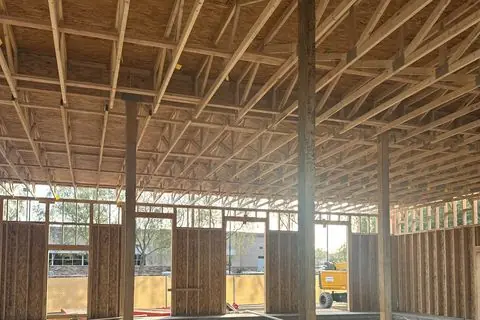 Wood roof trusses and support posts over the open floor of The Industry Studios, Henderson NV