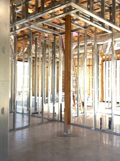 Metal stud framing for private office suites on the poured concrete slab at The Industry Studios, Henderson NV, September 2026